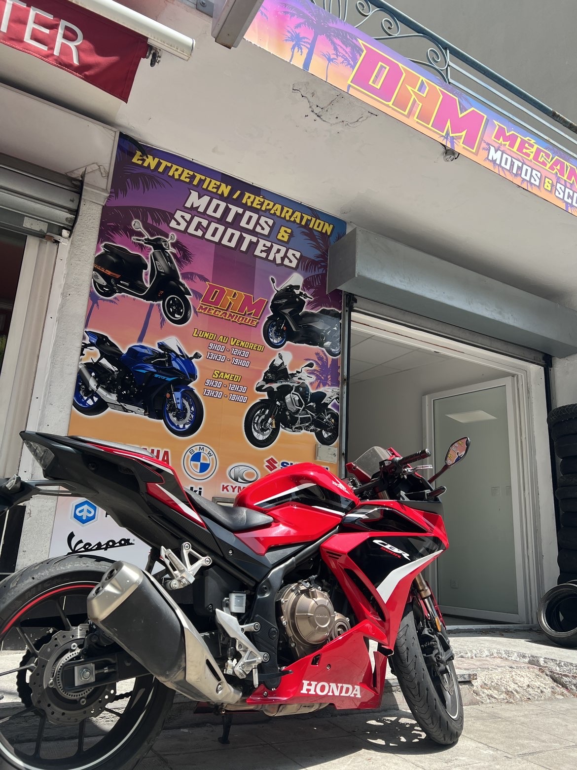 Honda CBR rouge devant le garage