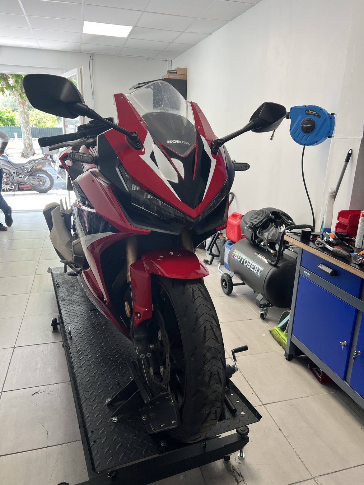 Moto sportive rouge sur le pont de l'atelier