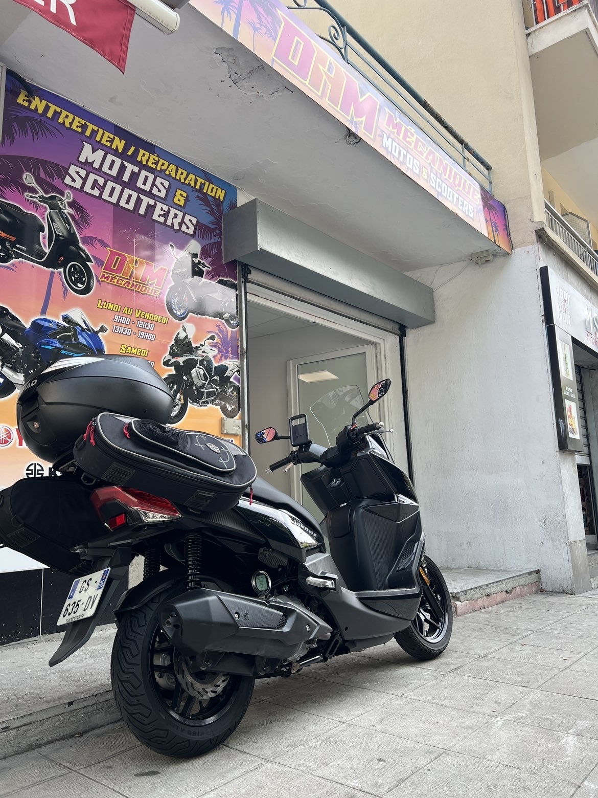 Maxi-scooter devant le garage DHM Mécanique
