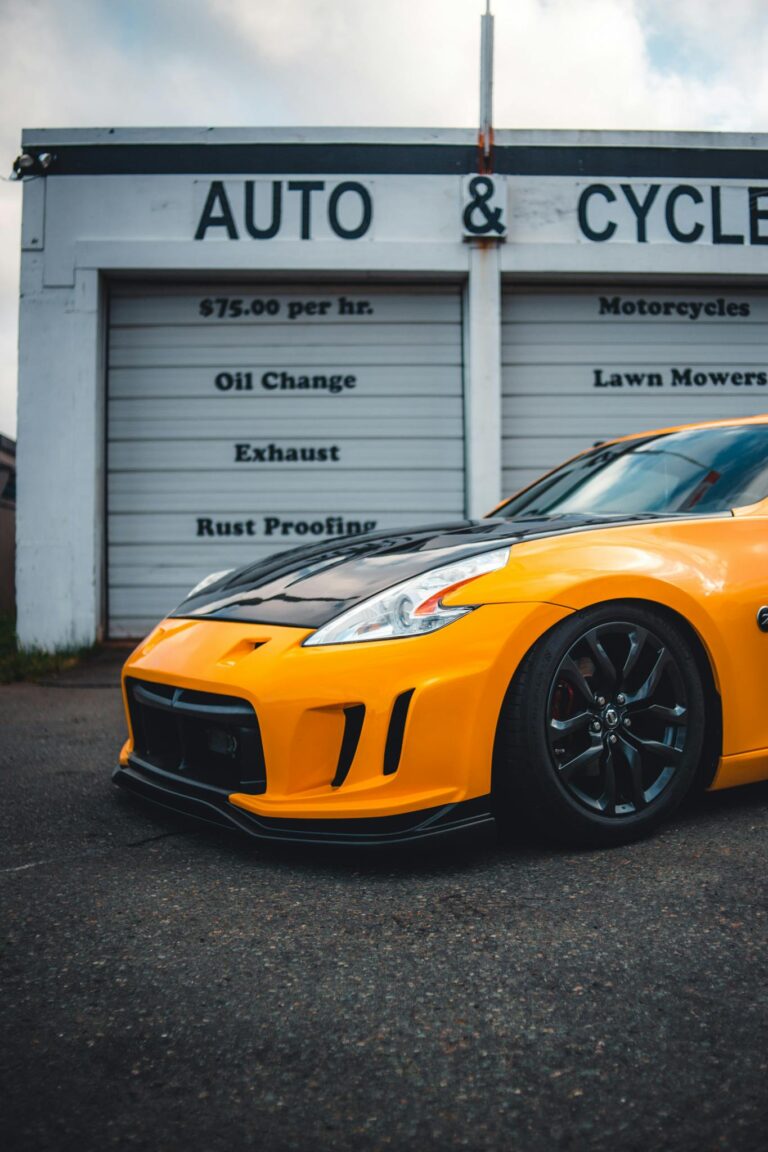 Yellow sports car parked outside an auto and cycle shop, showcasing bold design and sleek performance.